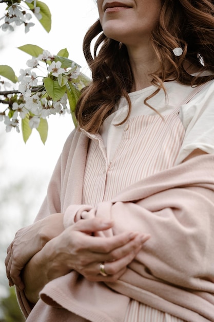 Ritratto di donna sicura di sé adulta godendo di fioritura nel giardino di primavera