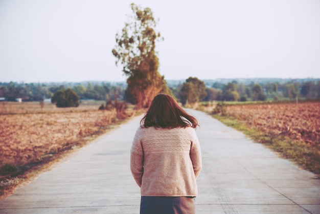 Ritratto di donna sola da sola in un campo Stile filtro vintageha il cuore spezzato dal concetto di ragazza amorosa sullo stile vintage tramonto