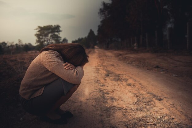 Ritratto di donna sola da sola in un campo Stile filtro vintageha il cuore spezzato dal concetto di ragazza amorosa sullo stile vintage tramonto