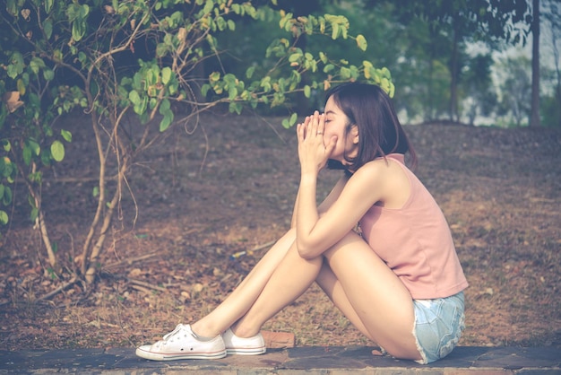 Ritratto di donna sola da sola in un campo Stile filtro vintageha il cuore spezzato dal concetto di ragazza amorosa sullo stile vintage tramonto