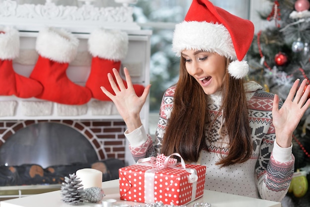 Ritratto di donna sorridente con un regalo di Natale a casa