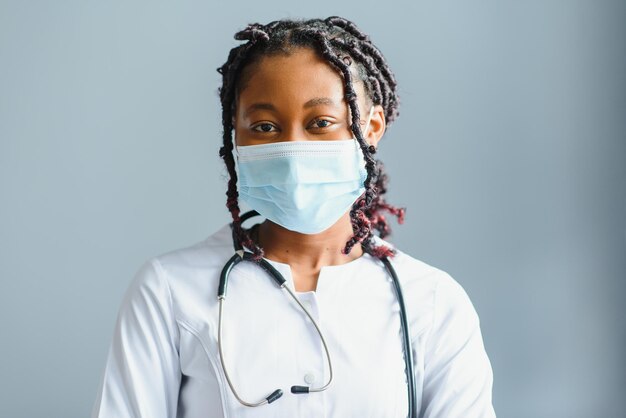 Ritratto di dottoressa sorridente che indossa camice bianco con lo stetoscopio in ufficio ospedaliero