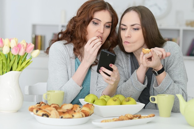 Ritratto di due amiche che guardano lo smartphone