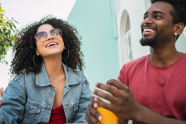 Ritratto di due amici afro divertendosi insieme e godersi un buon tempo bevendo succo di frutta fresca all'aperto presso la caffetteria.