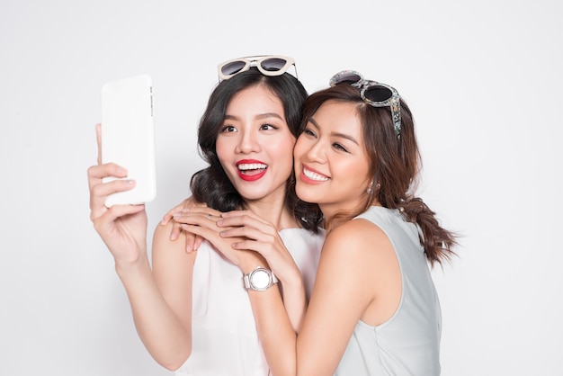 Ritratto di due belle donne asiatiche alla moda che prendono selfie