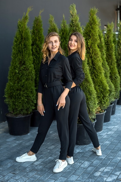 Ritratto di due belle ragazze vicino al thuja. stile di vita