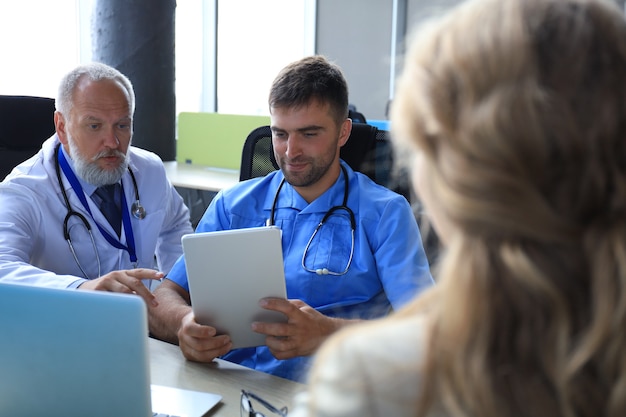 Ritratto di due professionisti che consultano il paziente in ospedale.