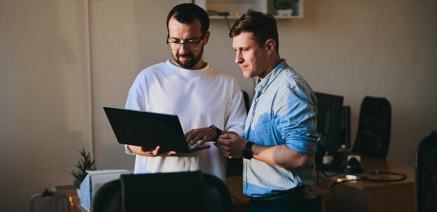 Ritratto di due programmatori maschi professionisti che lavorano su computer in diversi uffici Moderne tecnologie IT sviluppo di applicazioni di programmi di intelligenza artificiale e concetto di videogiochi