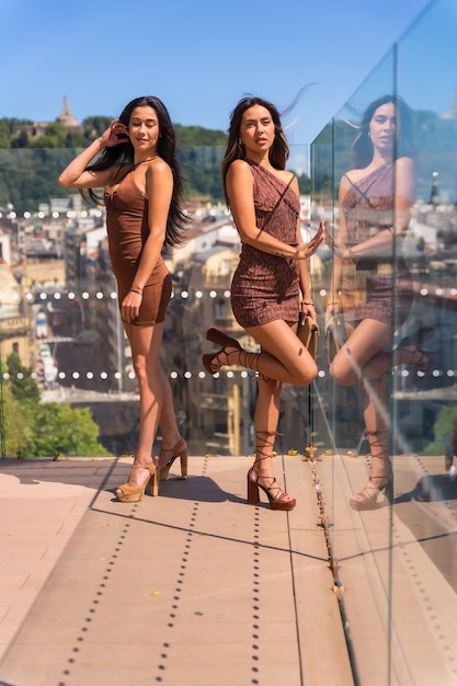 Ritratto di due sorelle che si godono le vacanze estive in un punto panoramico della città al bicchiere