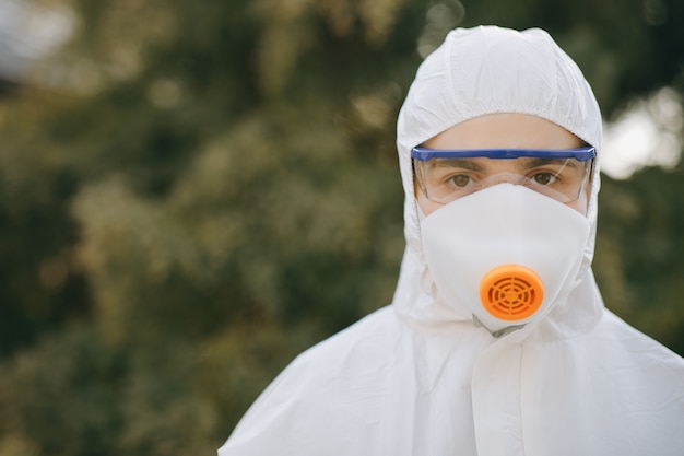 Ritratto di epidemiologo medico in lotta con il coronavirus COVID-19. Protezione mers da virologo. Tuta medica bianca con maschera, guanti, occhiali. Faccia della crisi globale durante l'epidemia.