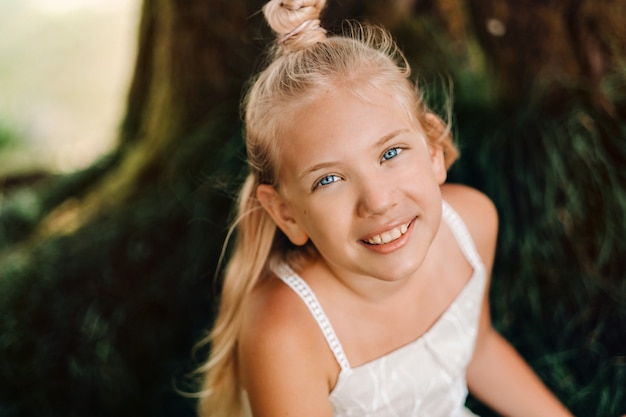 Ritratto di estate di una bambina felice sull'isola di Mauritius. Bel sorriso, abito bianco estivo.