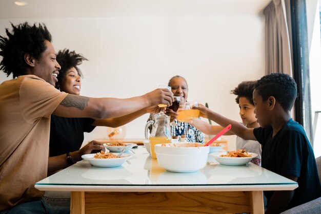 Ritratto di famiglia afro-americana a pranzo insieme a casa. Concetto di famiglia e stile di vita.