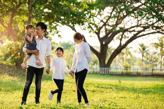 Ritratto di famiglia asiatica con la gente felice che sorride al concetto del parco, di stile di vita e di festa