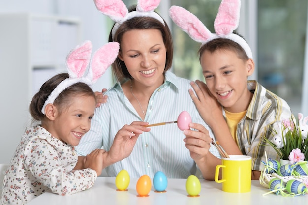 Ritratto di famiglia che dipinge le tradizionali uova di Pasqua in diversi colori a casa