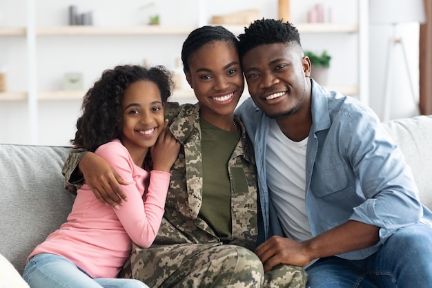 Ritratto di famiglia di felice ragazzo nero marito e moglie militare