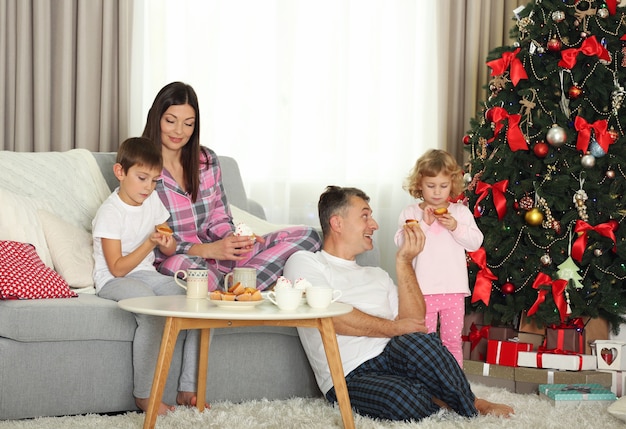 Ritratto di famiglia di Natale a colazione nel soggiorno di casa per le vacanze, al mattino