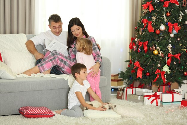 Ritratto di famiglia di Natale nel soggiorno delle vacanze di casa, al mattino
