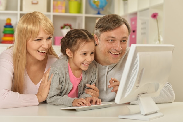 Ritratto di famiglia felice che gioca al computer a casa