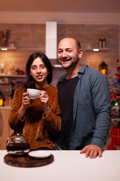 Ritratto di famiglia felice che guarda nella telecamera mentre celebra le vacanze invernali di natale