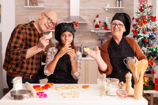 Ritratto di famiglia felice che indossa un grembiule con biscotti fatti in casa pasta