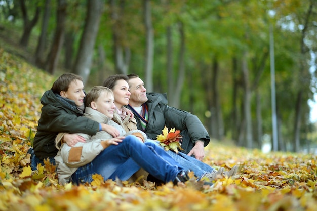 Ritratto di famiglia felice che si rilassa nel parco autunnale