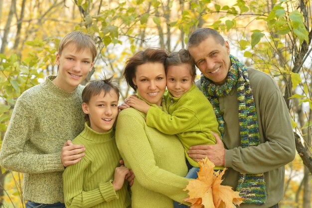 Ritratto di famiglia felice che si rilassa nel parco autunnale