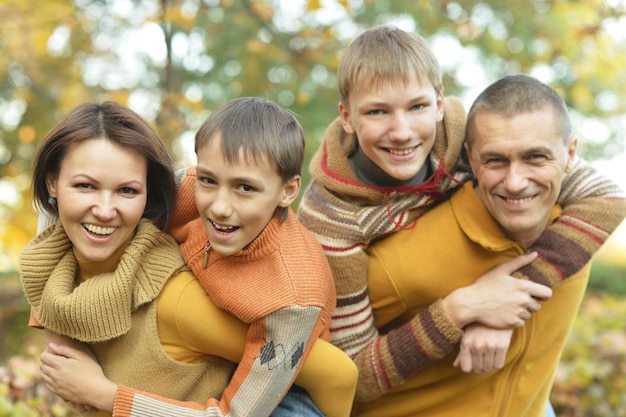 Ritratto di famiglia felice che si rilassa nel parco autunnale