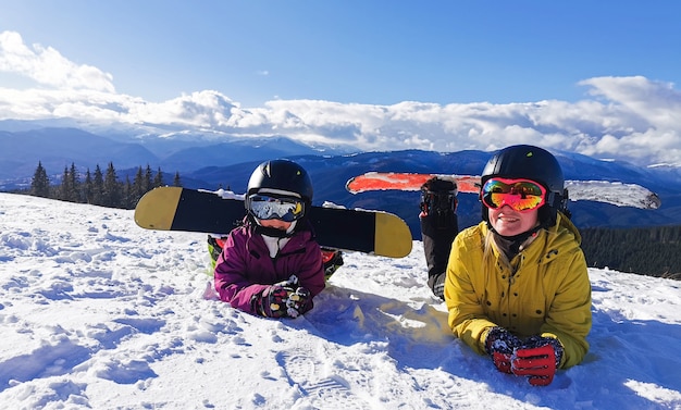 Ritratto di famiglia felice con snowboard guardando la fotocamera su sfondo blu