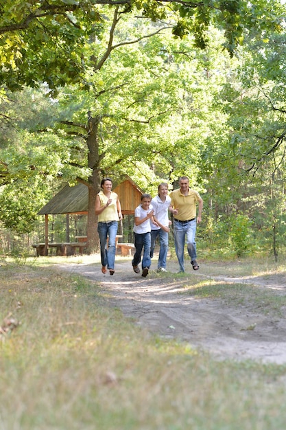 Ritratto di famiglia felice di quattro persone in autunno parco in esecuzione