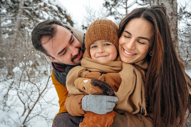 Ritratto di famiglia felice in abiti invernali nella foresta