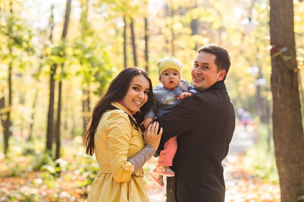 Ritratto di famiglia felice in giardino sulla natura autunnale