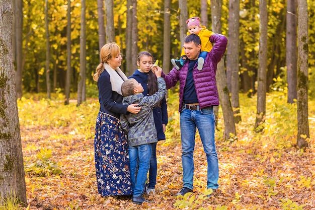 Ritratto di famiglia felice in giardino sulla natura autunnale