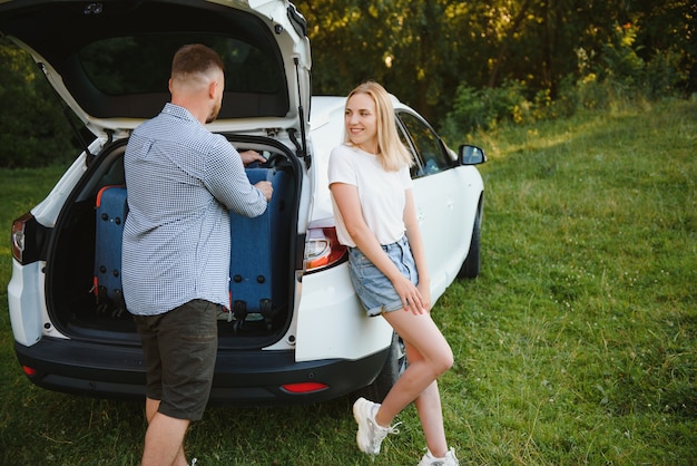 Ritratto di famiglia felice. Vacanze, viaggi - famiglia pronta per il viaggio per le vacanze estive. valigie e percorso auto.