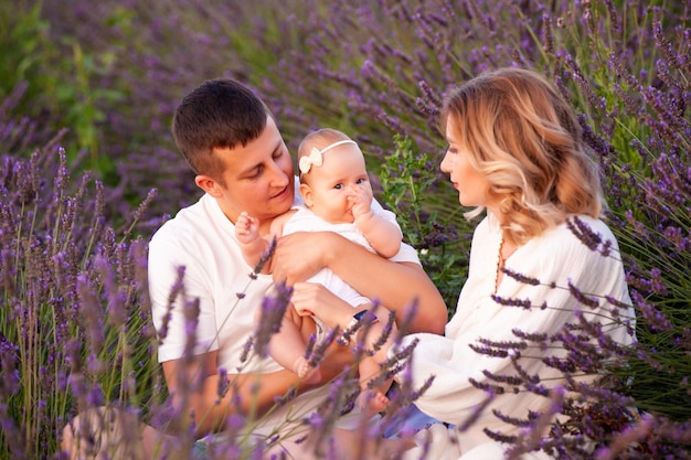 Ritratto di famiglia madre padre e bambino sul campo di lavanda divertendosi insieme. Coppia felice con il bambino