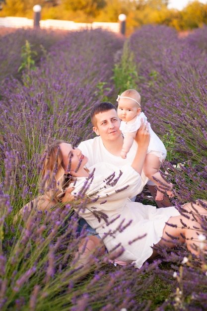 Ritratto di famiglia madre padre e bambino sul campo di lavanda divertendosi insieme. Coppia felice con il bambino