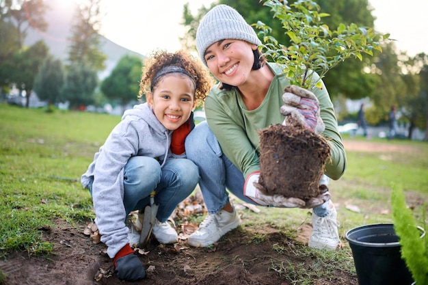 Ritratto di famiglia pianta e giardinaggio in un parco con alberi in natura ambiente agricoltura o giardino Felice donna volontaria e bambino che piantano per la crescita ecologia e sostenibilità della comunità