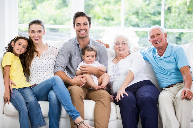 Ritratto di famiglia sorridente con i nonni, seduti sul divano