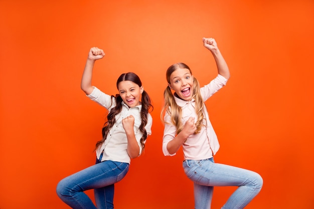 Ritratto di fanatici di sport estatici pazzi bambini guardare gioco di squadra celebrare urlo di vittoria sì alzare i pugni indossare abbigliamento moderno stile casual isolato su sfondo di colore brillante