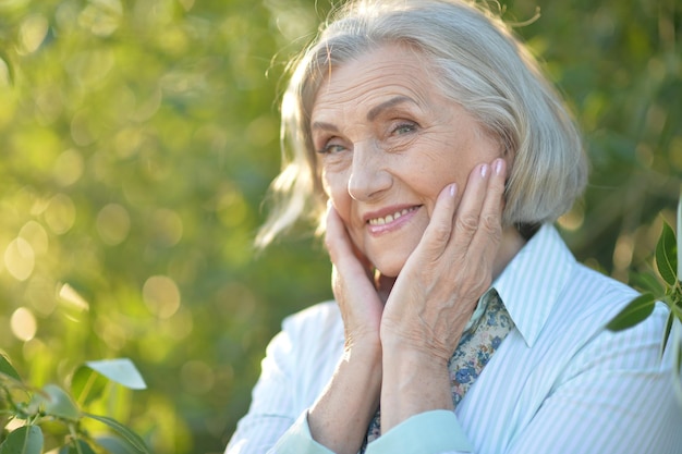 Ritratto di felice bella donna anziana in posa all'aperto