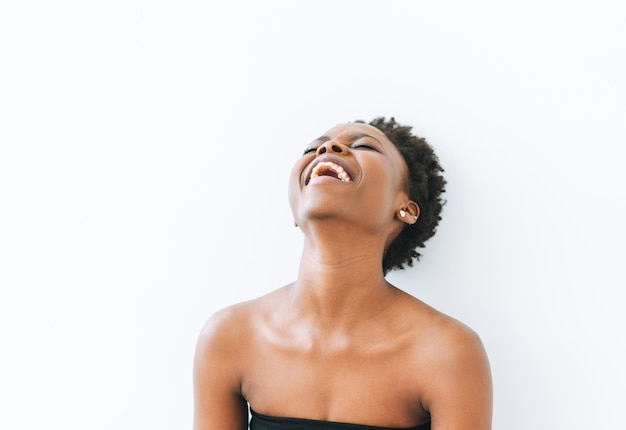 Ritratto di felice bella giovane donna afroamericana in cima nera isolata su sfondo bianco