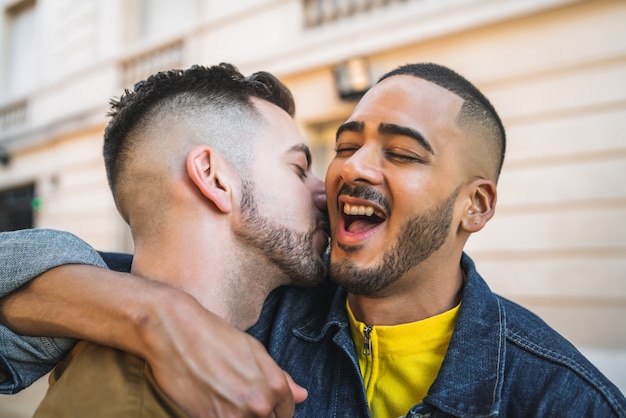 Ritratto di felice coppia gay di trascorrere del tempo insieme e abbracciando in strada. Lgbt e concetto di amore.