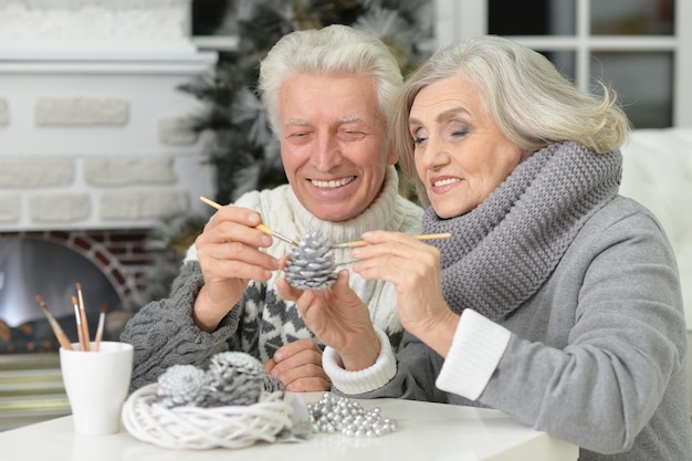 Ritratto di felice coppia senior che si prepara per il Natale a casa