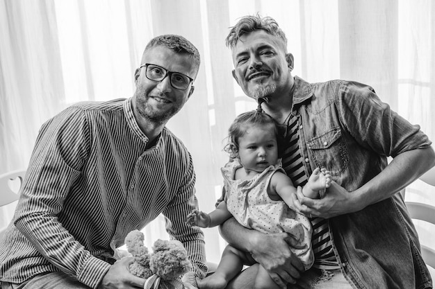 Ritratto di felice famiglia LGBTQ a casa Coppia gay e figlia Concetto di diversità e relazione familiare LGBTQ Bianco e nero