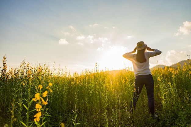 Ritratto di felice giovane e felice felice relax nel parco. Modello femminile gioiosa che respira aria fresca all&#39;aperto e godendo odore in una primavera di fiori o giardino estivo, tono d&#39;annata