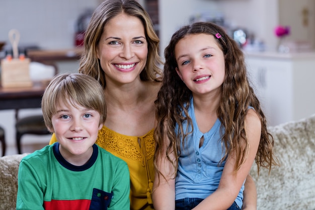 Ritratto di felice madre e bambini seduti su un divano