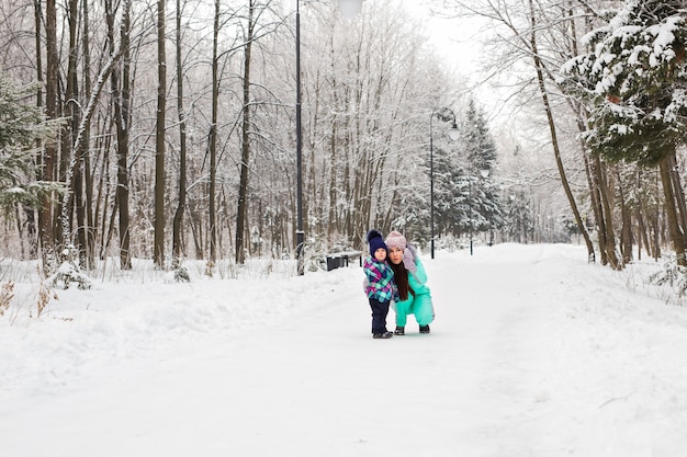 Ritratto di felice madre e bambino nel parco invernale.