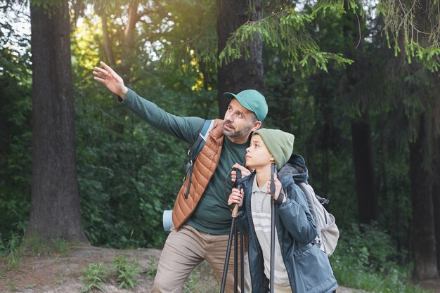 Ritratto di felice padre e figlio che prendono selfie durante le escursioni insieme e passeggiate nella foresta, copia dello spazio