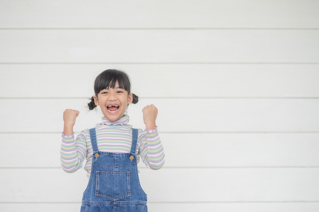 Ritratto di felice piccolo bambino asiatico su sfondo bianco