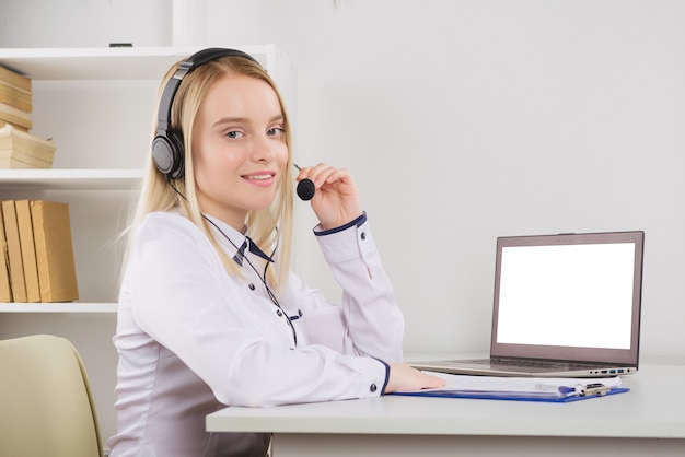 Ritratto di felice sorridente operatore telefonico di assistenza clienti femminile sul posto di lavoro.