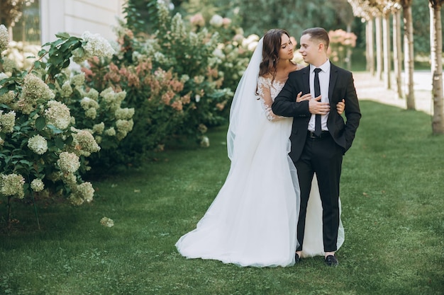 Ritratto di felice sposa e sposo con testa a testa in giardino